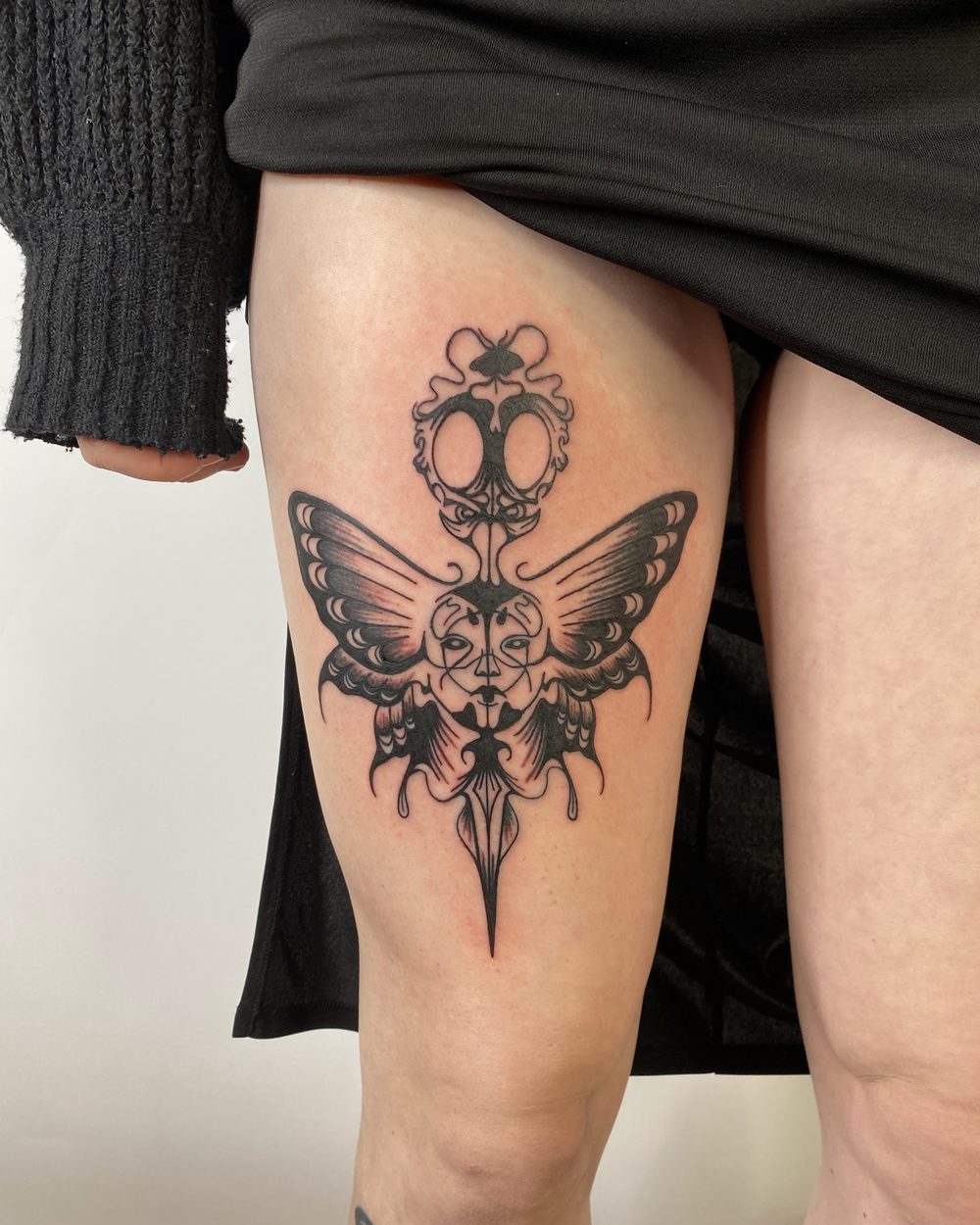 Dagger wrapped in flame down the inside of a forearm