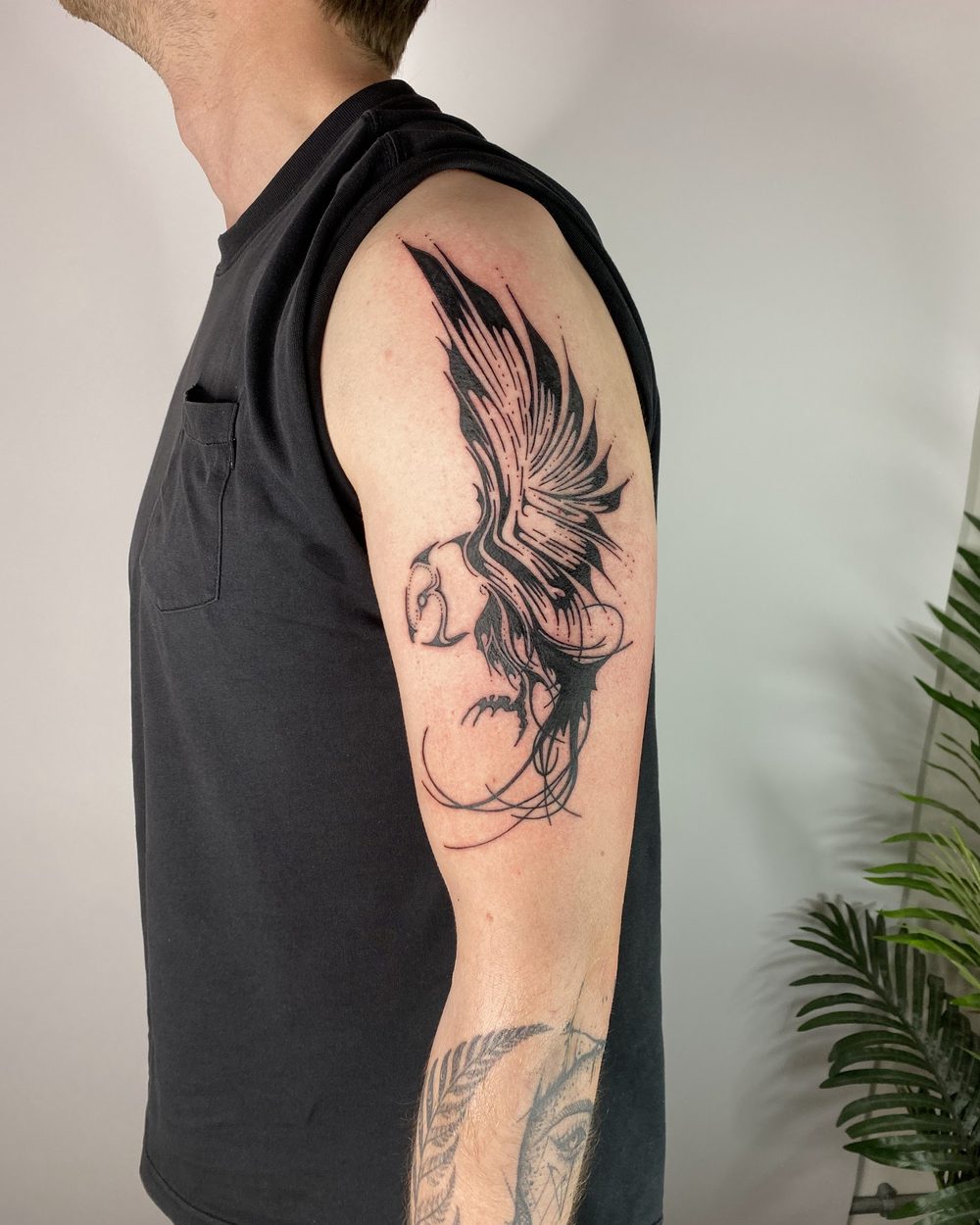 Ram skull framed by wings across an upper back