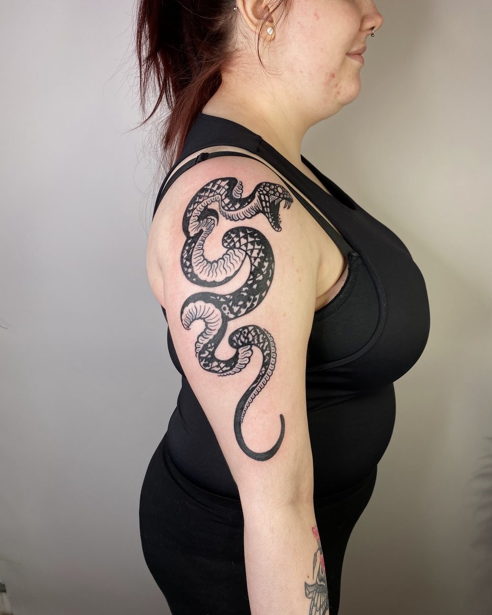 Winged lion rising up the outside of an upper arm