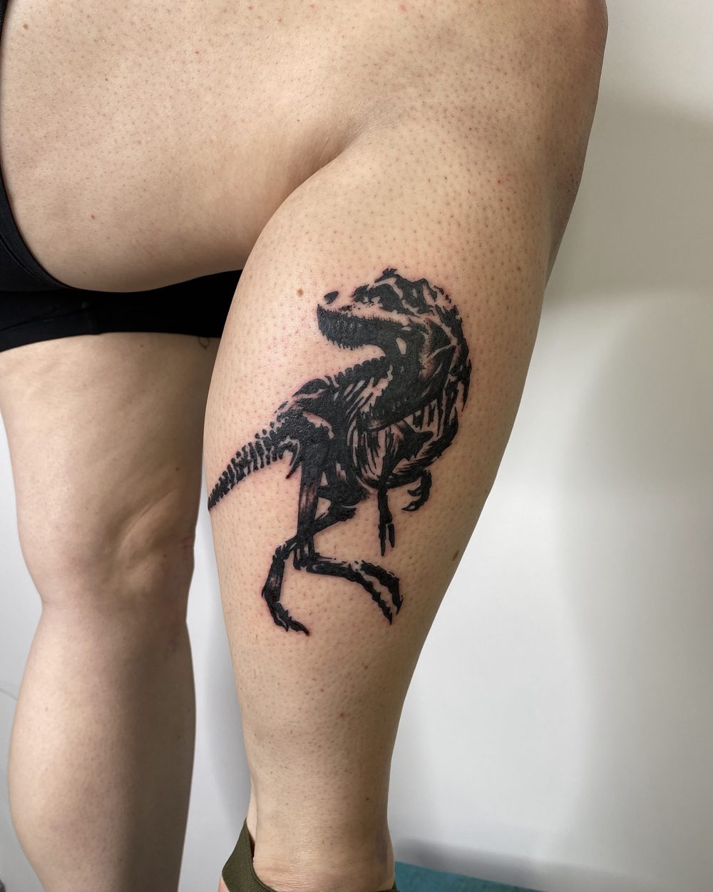 Winged figure over drawn linework on a lower leg