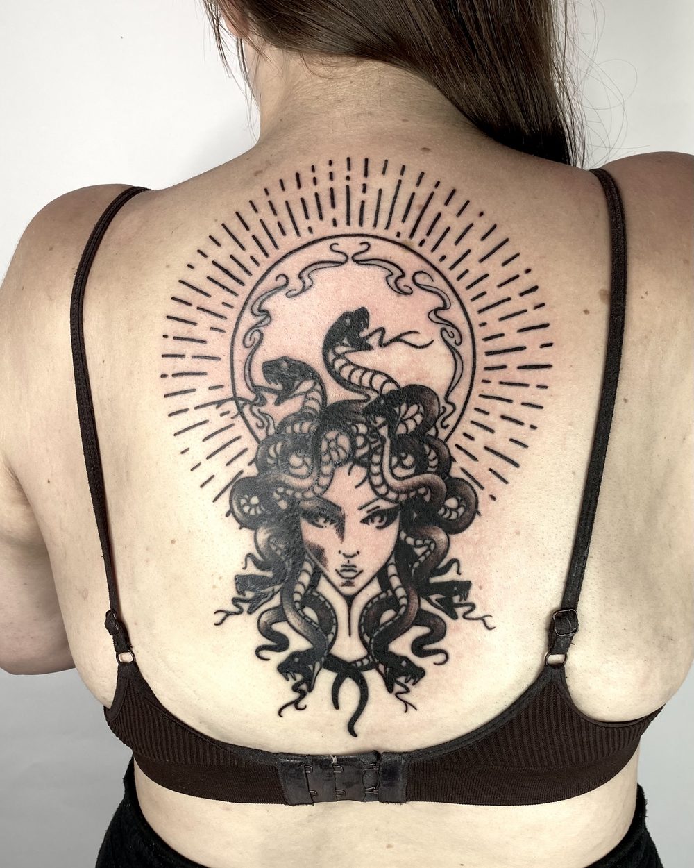 Medusa portrait with a radiating halo across an upper back